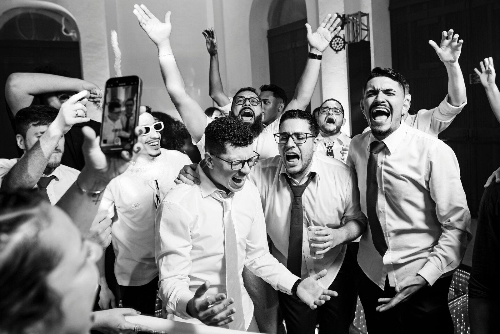 Group of men celebrating in a joyful indoor event, expressing fun and excitement.